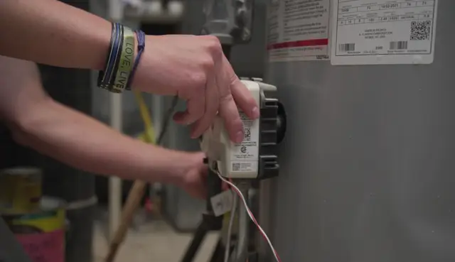 Technician adjusting a water heater's gas control valve