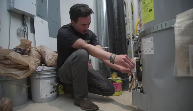 Technician checking the gas control on a tank water heater