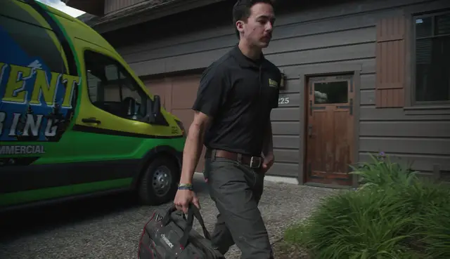 Element plumber walking from the van to a home with his tool bag