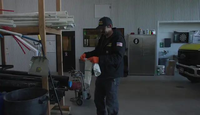 Plumber preparing a drain cleaning machine in the shop
