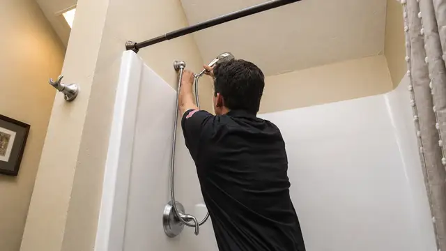 Element plumber adjusting a showerhead and shower fixture