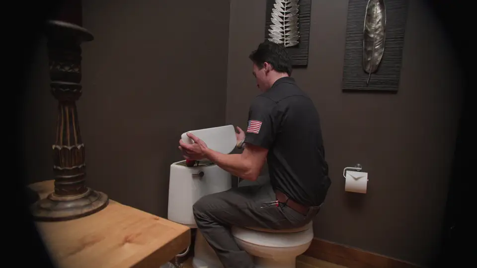 Element plumber repairing the parts inside a toilet tank