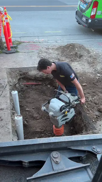 Plumber working in an excavation on an underground line