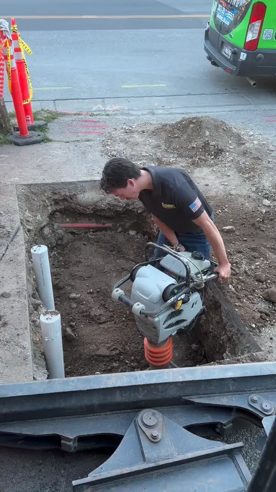 Plumber working in an excavation on an underground line