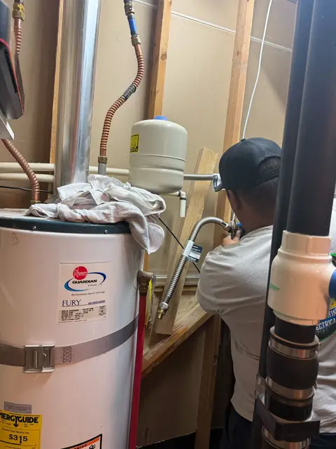 Technician installing an expansion tank during a water heater repair