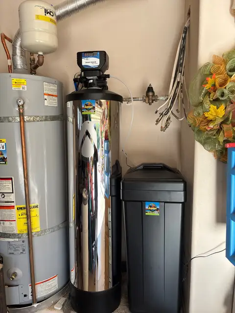 Whole-home water softener installed beside a water heater